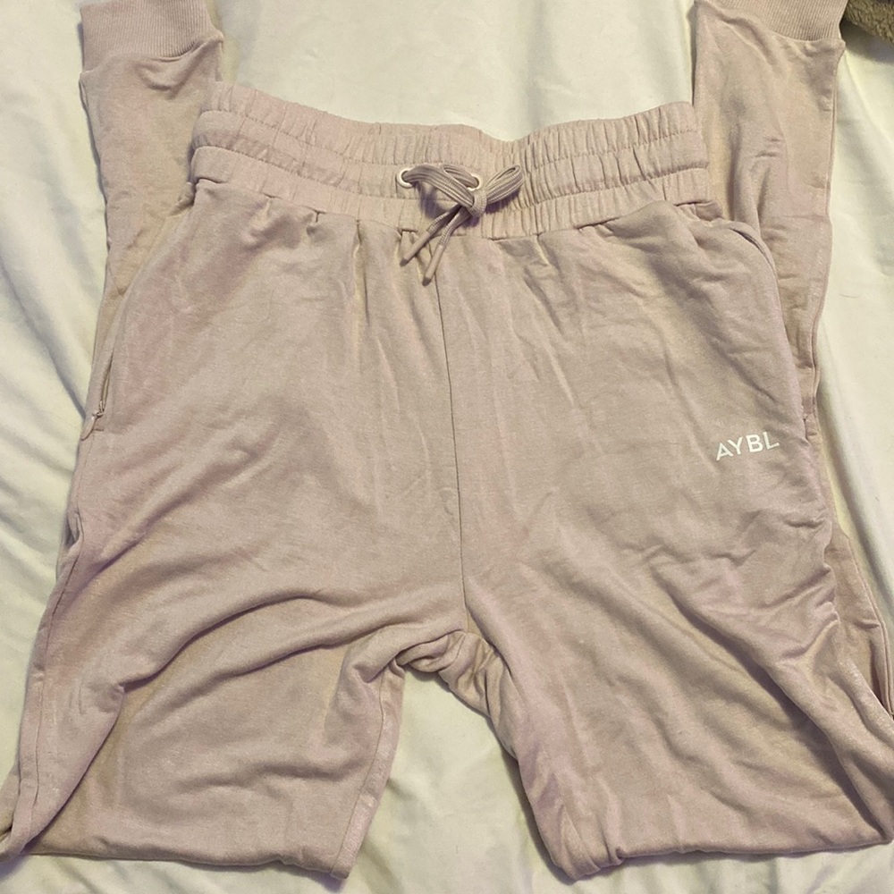 Size XS AYBL joggers. They’re a sand grey but I believe they have a pink tint.